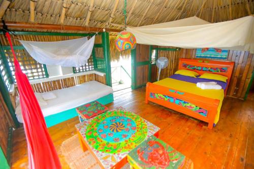 Tintipan IslandHotel Puntanorte的一间卧室配有一张床、一张床和一个帐篷