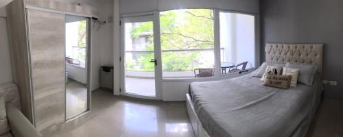 罗萨里奥Loft Espectacular Céntrico con Garaje的一间卧室设有一张大床和一个大窗户
