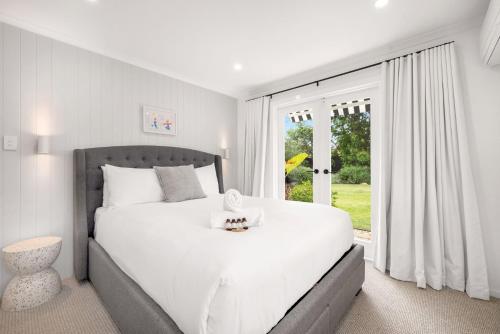 斯卡伯勒Serenity by the Sea的白色的卧室设有一张大床和一个窗户