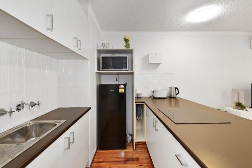 Long JettyAllamanda Unit 22的厨房配有黑色冰箱和水槽