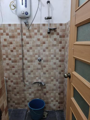 Keneth Hostel的一间带淋浴的浴室,里面装有水桶