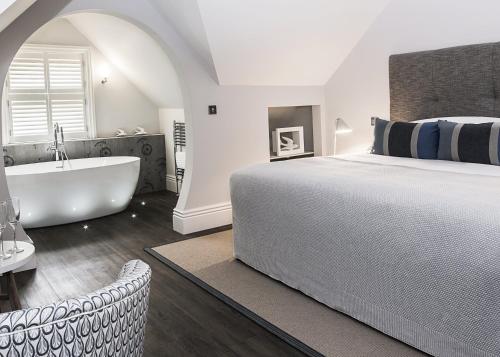 谢菲尔德布罗科公园精品酒店的一间卧室设有一张大床和一个浴缸