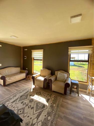 普耶韦Cabañas del Llano的客厅配有两张床、一张沙发和一个地毯。