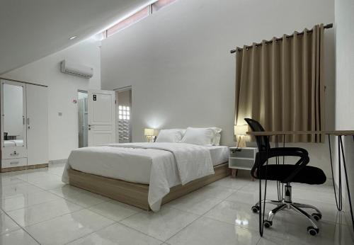 雅加达9 Residence Guesthouse Syariah Cilandak的一间卧室配有一张床、一张桌子和一把椅子