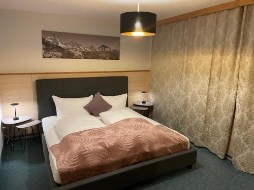 皮茨河谷圣莱昂哈德格莱赛小木屋酒店的一间卧室配有一张大床和两张桌子