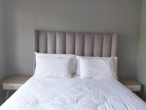 SandtonVic's place - With backup power的白色的床、白色床单和枕头