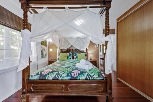 埃尔利海滩艾里度假屋 - 艾里海滩的一间卧室配有一张带绿色枕头的天蓬床