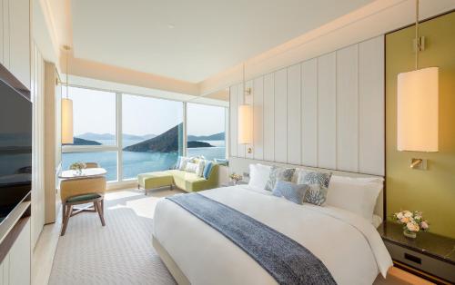 香港香港富丽敦海洋公园酒店的一间卧室设有一张大床和一个大窗户