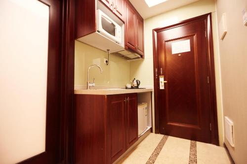 广州广州市骏田国际酒店公馆的一个带水槽和木门的小厨房