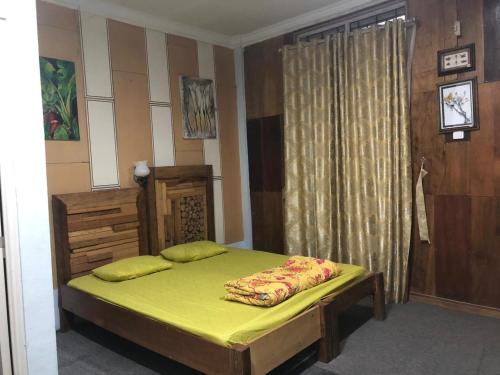 不拉士打宜Friendjoss Homestay Laugumba RedPartner的一间卧室配有一张带黄色床单的床和一扇窗户。
