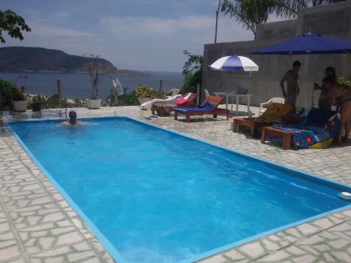 尼泰罗伊米兰特贝拉维斯塔民宿的在蓝色游泳池游泳的人