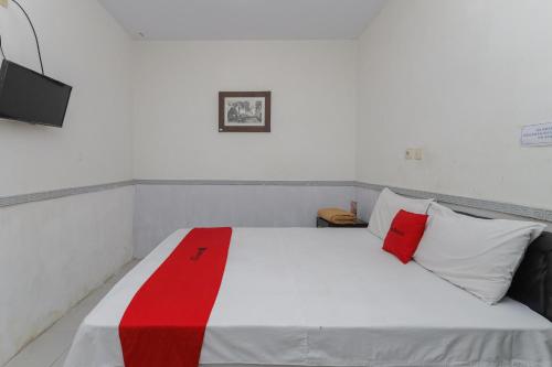 玛琅RedDoorz near Stasiun Malang Kota Lama 2的一间卧室配有红色和白色枕头的床