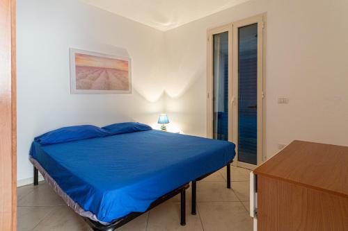 托雷莫泽Appartamento climatizzato a 50 m dalla spiaggia con patio esterno的一间卧室配有一张蓝色的床和一张桌子