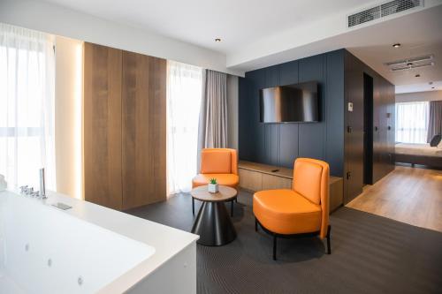 地拉那Hotel Elisa Tirana, Affiliated by Meliá的一间设有两张橙色椅子和一张桌子的房间