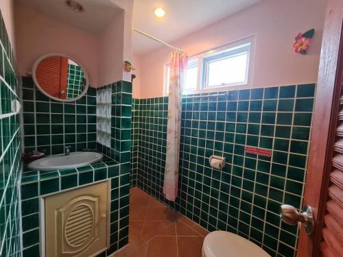 华欣The Phen House的浴室设有绿色瓷砖墙壁和水槽