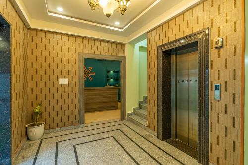 达兰萨拉Zostel Plus Kareri的酒店大堂设有玻璃门和楼梯