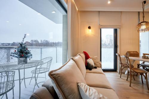 奥尔什丁Apartament Kominek, Jezioro & Las的客厅配有沙发和带圣诞树的桌子