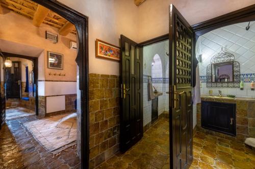 瓦尔扎扎特Hôtel Riad Dar Daïf的带门和浴室的客房入口