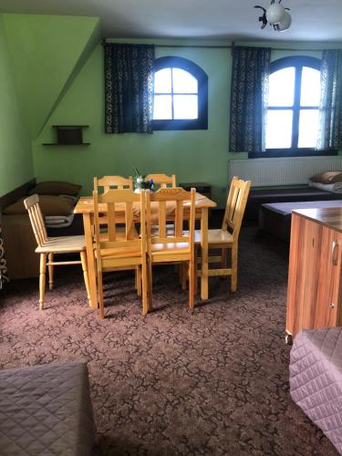 扎科帕内Międzynarodowe Schronisko Młodzieżowe PTSM Szarotka的一间带木桌和椅子的用餐室