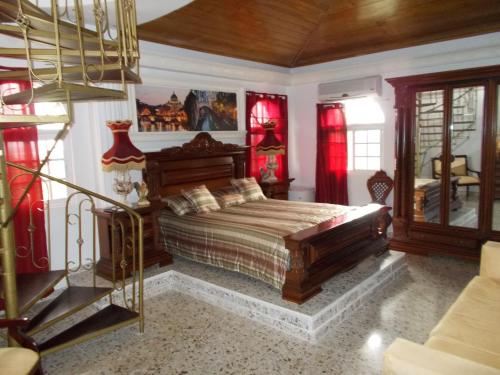 拉斯特拉纳斯卡斯蒂略罗曼诺旅馆的一间设有床铺的卧室,位于一间设有红色窗帘的房间