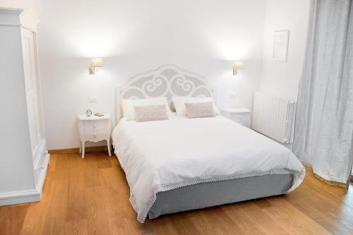 维罗纳坎托雷住宿酒店的白色卧室配有一张带白色床单和枕头的大床