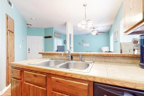 帕德雷岛Lyla's Beach Getaway的厨房配有不锈钢水槽和蓝色的墙壁