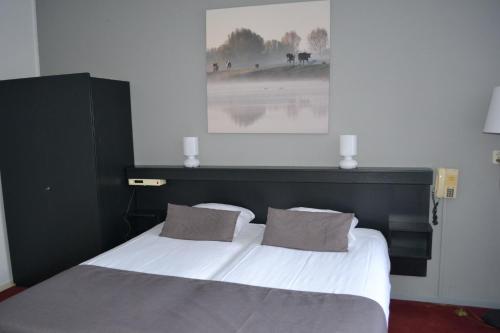 埃尔斯佩特斯塔肯贝格陆威酒店的卧室配有一张带两个枕头的大白色床