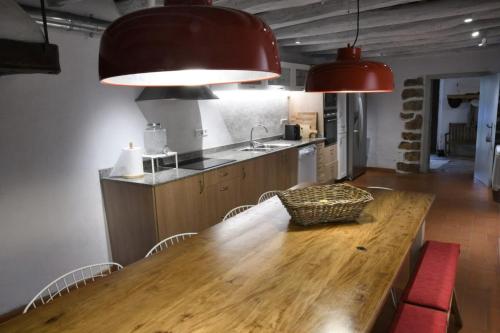 圣塔克里斯蒂纳阿鲁Masia Can Pitu的厨房配有木桌、椅子和2盏灯