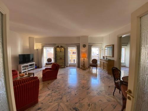 罗马VHOMETREVI的大型客厅配有红色椅子和电视