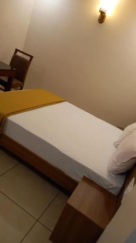 MamaGreenpark Residence的一张小床,位于带椅子的房间里