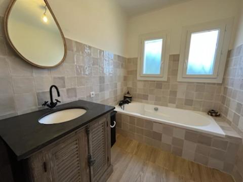 弗雷瑞斯Villa Junna的一间带水槽、浴缸和镜子的浴室