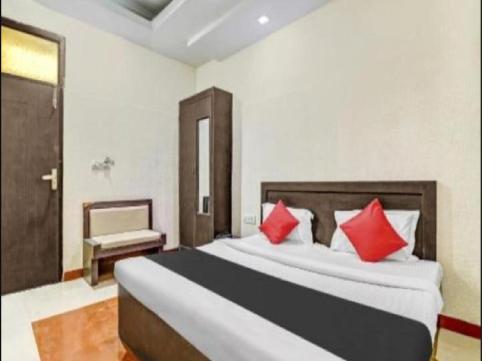 阿格拉Om Sai Nath Hotel & Restaurant By WB Inn的一间卧室配有一张带红色枕头的大床