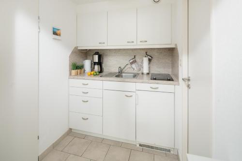 诺德奈Kaiserperle 114的白色的厨房配有白色橱柜和水槽