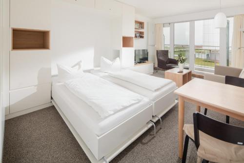 诺德奈Kaiserperle 114的白色的卧室配有白色的床和一张桌子