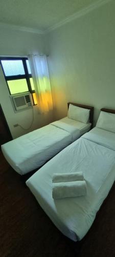 TalisayRedDoorz Plus at Balai Sofia Bed & Breakfast Batangas的带窗户的客房内的两张床