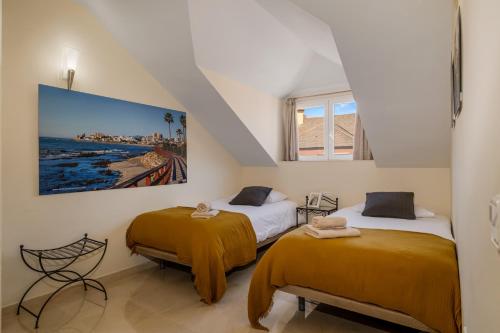 索托格兰德Luxury Penhouse, Sotogrande Marina - Located in an exclusive island of the Marina的墙上画画的房间里设有两张床