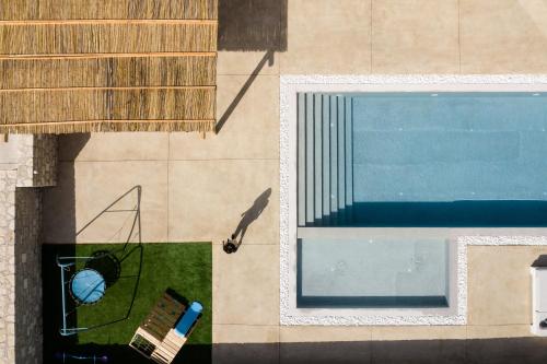 AchladesAyali Villa II, a divine luxury homestay, By ThinkVilla的游泳池顶部景色,设有长凳