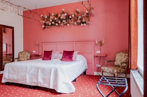 BabberichLandgoed Halsaf的粉红色的卧室,配有一张床和两把椅子