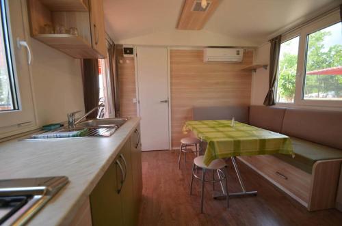 塞利讷Campsite Pisak - mobile homes by the sea的厨房配有一张桌子,上面有绿桌布