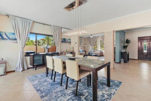 棕榈滩Bocobay Gold Coast Resort的用餐室以及带桌椅的起居室。