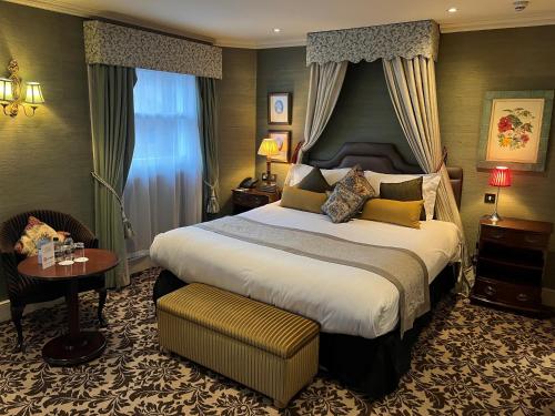 伦敦里奥纳德酒店的酒店客房设有一张大床和一张桌子。
