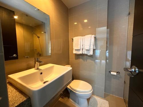 马尼拉Uptown BGC Luxury 1br Suite with Fast Wifi的一间带水槽、卫生间和淋浴的浴室