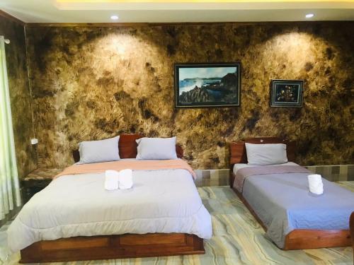 沙湾拿吉xaythone guest house的一间卧室设有两张床和石墙