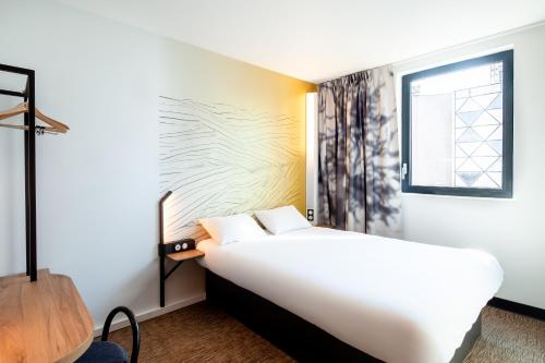 第戎B&B HOTEL Dijon Valmy Toison d'or的卧室配有白色的床和窗户。