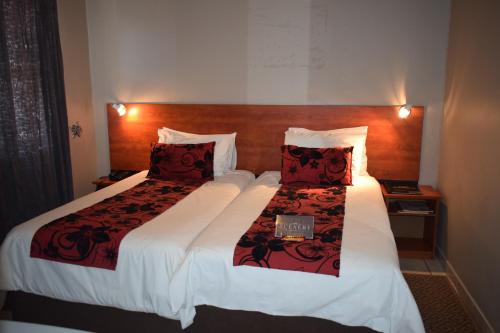 马塞卢Scenery Guesthouse Stadium的酒店客房 - 带两张带红色枕头的床