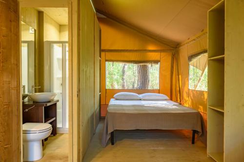 卡斯蒂里昂纳·德拉佩马雷玛圣苏西露营酒店的一间卧室配有床、水槽和卫生间