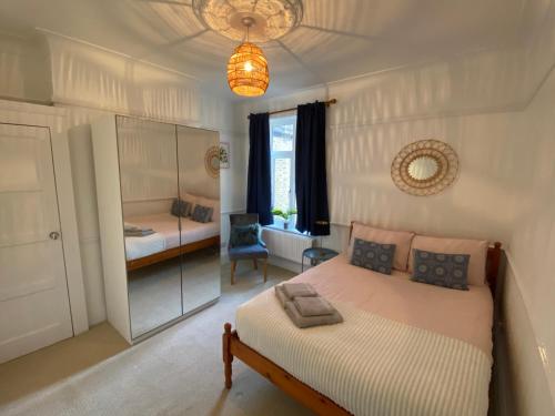 伦敦Lovely 3 bedroom maisonette with private roof terrace in Hammersmith的一间卧室配有一张床和一把椅子