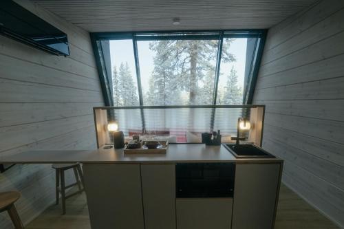 萨拉Salla Wilderness Lodges的厨房配有桌子和大窗户