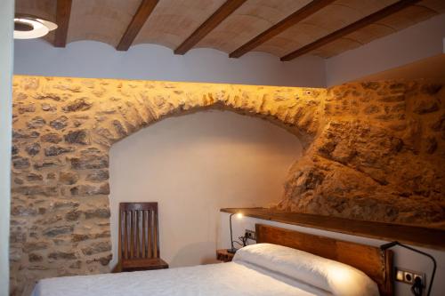 EstormCasa Sanui. Apartaments turístics rurals的石墙房间内的一张床位