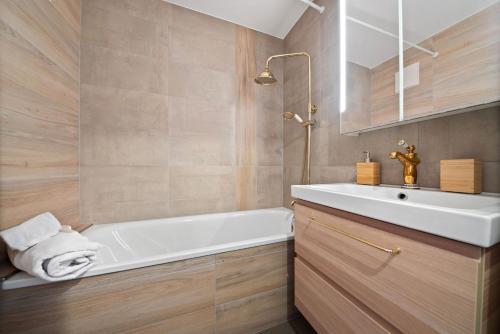 奥瓦伦纳茨Charmant studio rénové situé dans les bains d'Ovronnaz, immeuble les Sources的浴室配有白色浴缸和水槽